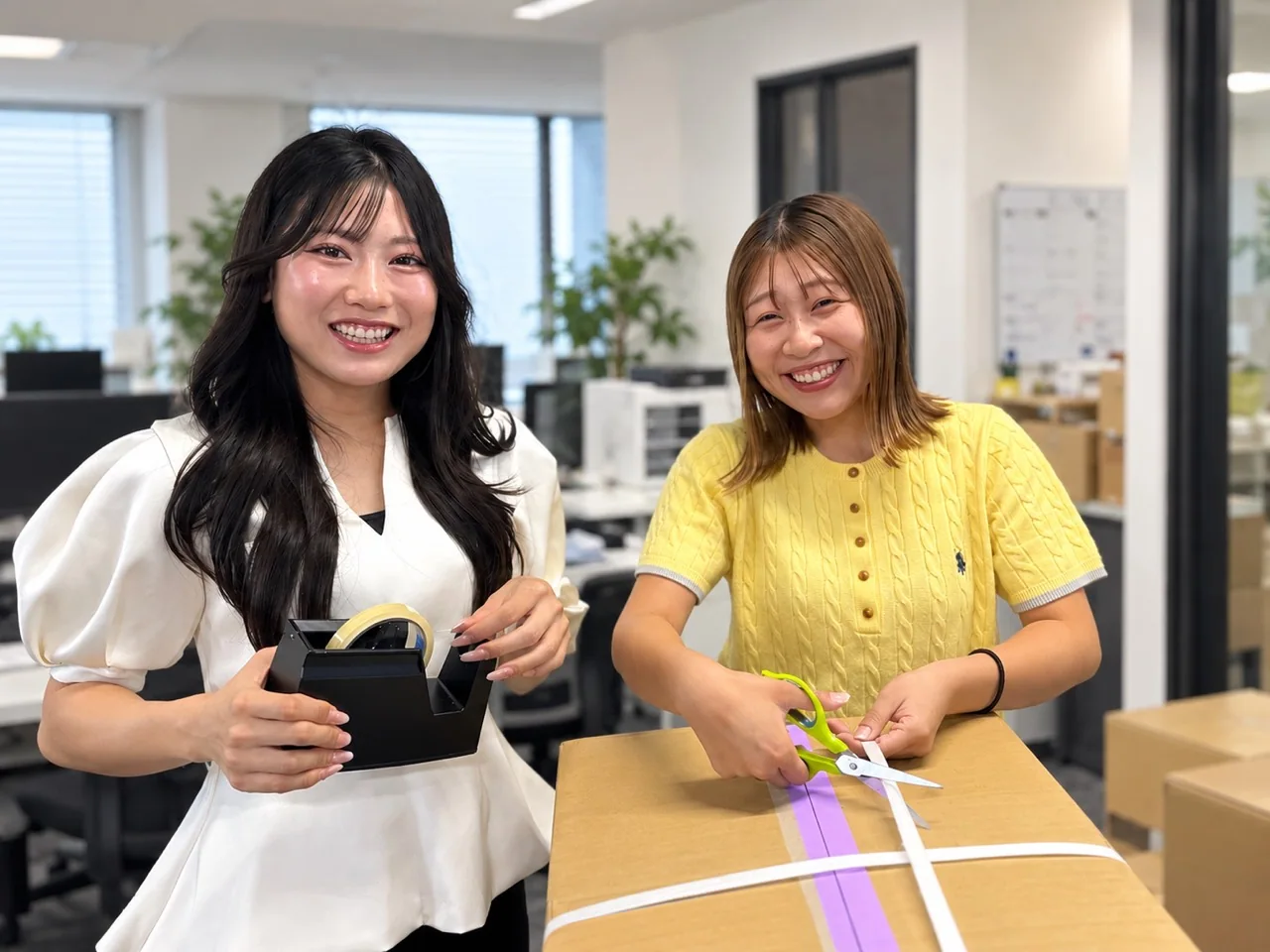 段ボールを囲んで笑顔を見せる2人