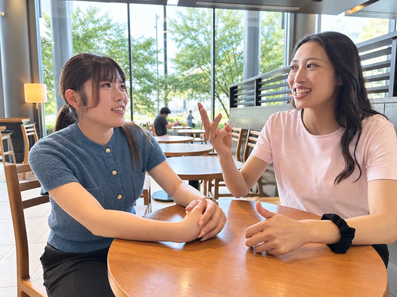 カフェの丸テーブルで会話する2人