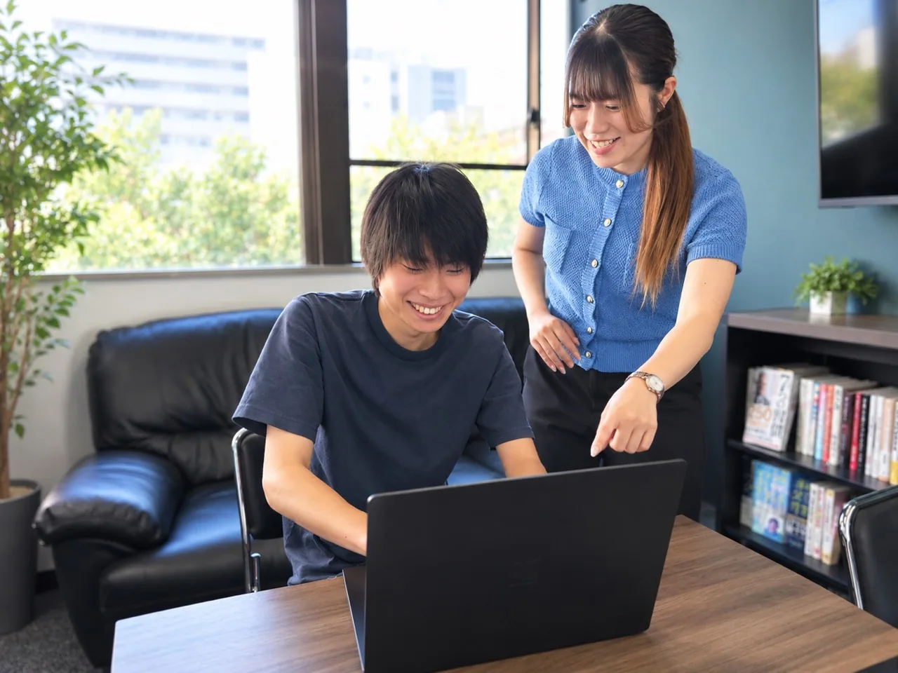 同じパソコンを見ながら話す二人