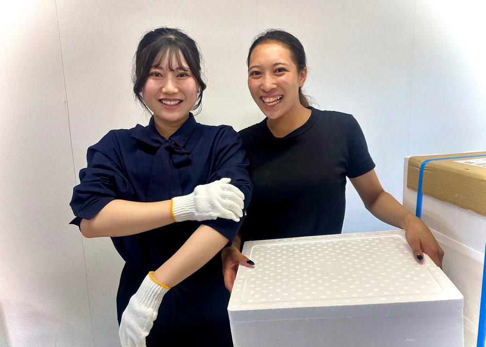 作業用の箱を持って笑顔を見せる二人